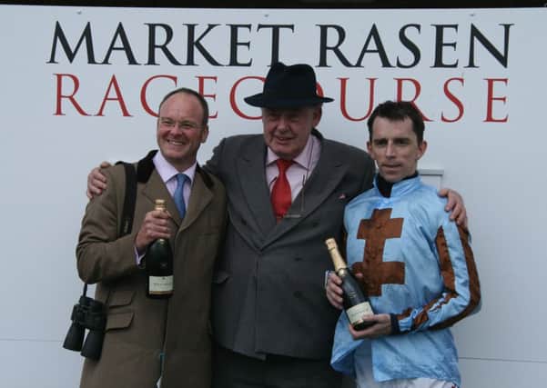 Peter Thompson Colin Booth (centre ) Chairman of Market Rasen Raceourse presents champagne to Grand National winning duo Dr. Richard Newlove (left) and jockey Leighton Aspell. EMN-140604-202617001