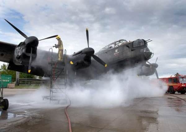 Fire crews tackel the engine fire which has put the BBMF's Laancaster Bomber out of action. Photo: RAF Crown Copyright