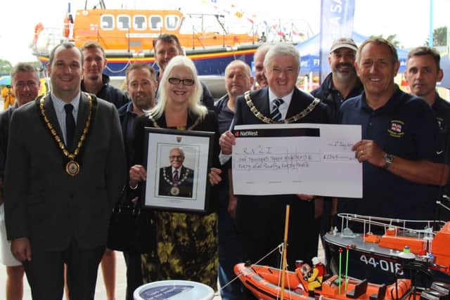 SKDC chairman Coun Ray Wootten hands over the cheque to coxswain Ray Chapman, accompanied by Coun Linda Wootten and Mayor of Skegness, Coun Carl Macey (front row, left) and RNLI Skegness Lifeboat crew.