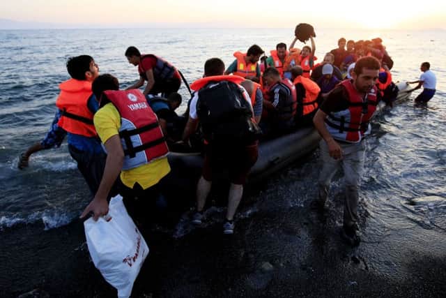 Refugees in a rubber dinghy arriving on the beach at Psalidi on Kos aecd6113-4790-48d2-a3c5-fa68b3b6