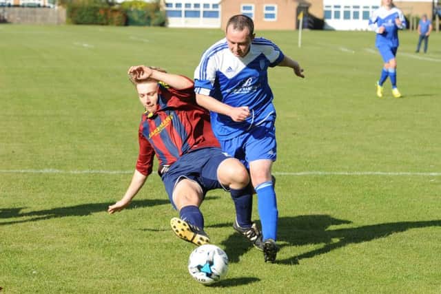 Railway's Connor Massam slides in on Old Dons' Ollie Gedney.