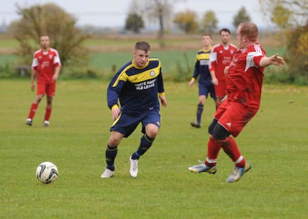 Billinghay's Simon Creasey clashes with Old Leake's James Leafe.