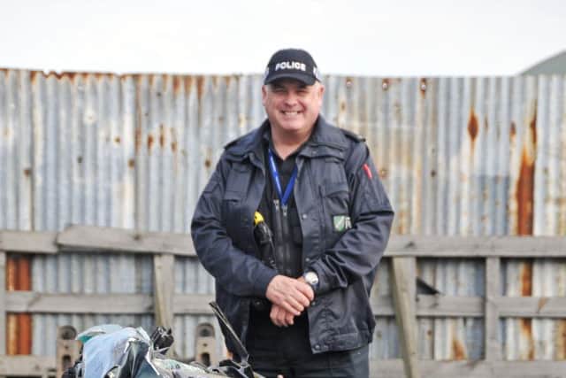 Lincolnshire Police rural and wildlife officer PC Nick Willey next to a vehicle crushed after it was seized by police because of its involvement in hare coursing. Photo by Tim Wilson.