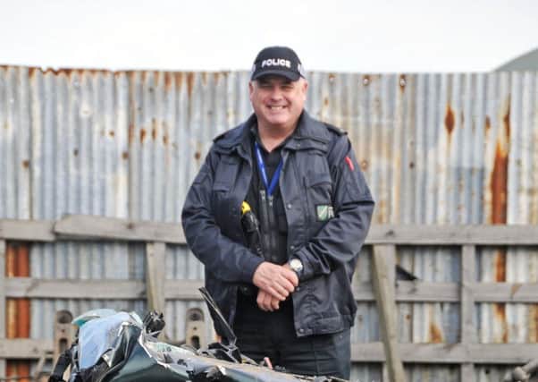 Lincolnshire Police rural and wildlife officer PC Nick Willey next to a vehicle crushed after it was seized by police because of its involvement in hare coursing.  Photo by Tim Wilson.