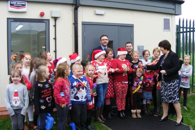 Coun Patricia Bradwell cuts the ribbon on the Food Cube at Mrs Mary Kings School in Martin, watched by pupils, headteacher Andrew Sewell and kitchen superviser Gavin Whitworth. EMN-151215-134134001