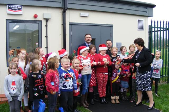 Coun Patricia Bradwell cuts the ribbon on the Food Cube at Mrs Mary Kings School in Martin, watched by pupils, headteacher Andrew Sewell and kitchen superviser Gavin Whitworth.