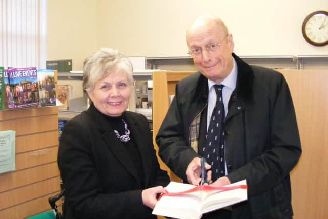 Local county councillor Barry Young cuts the ribbon to open Heckington library watched by parish council chairman Jan Palmer. EMN-151217-131845001