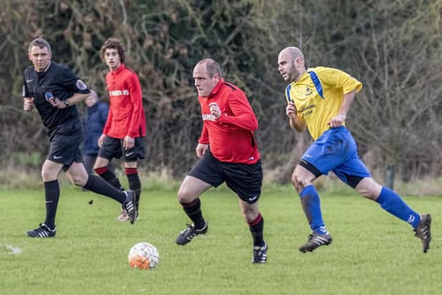 Coningsbys Lee Marshall makes a break for it during the derby game with Billinghay on Saturday. Photo: Oscarpix Imaging.