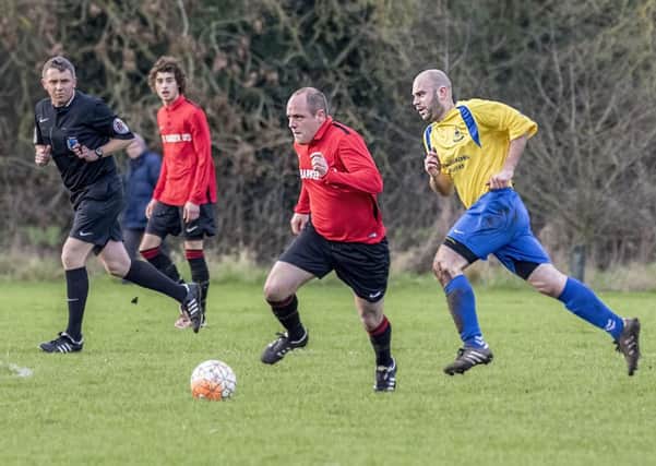 Coningsbys Lee Marshall makes a break for it during the derby game with Billinghay on Saturday. Photo: Oscarpix Imaging.