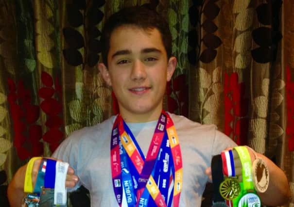 MARATHON MAN: William Chico of Caister Grammar School with his haul of medals after a year of marathons, half-marathons, duathlons and triathlons.