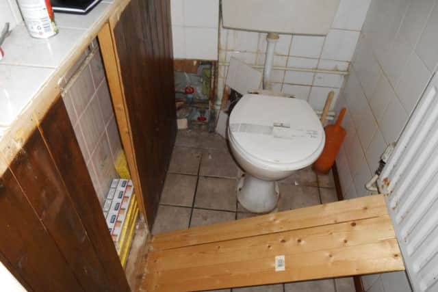 Illegal cigarettes were hidden behind a panel in a bathroom.