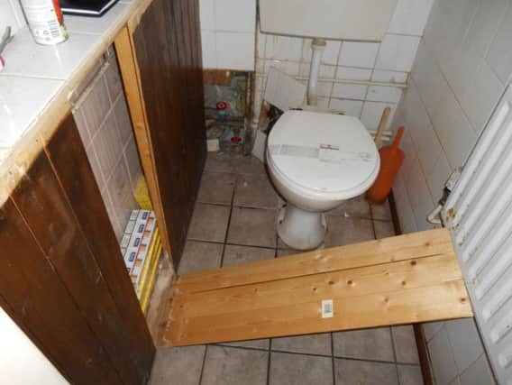 Illegal cigarettes were hidden behind a panel in a bathroom.