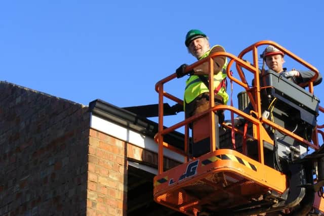 Going up in the world. Coun Stuart Ogden takes a ride in a 'cherry picker' to help kick off demolition work on the council houses on Newfield Road, Sleaford EMN-160123-164537001
