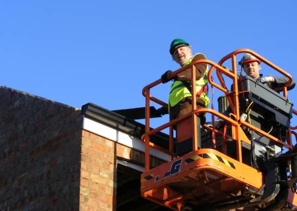 Going up in the world. Coun Stuart Ogden takes a ride in a 'cherry picker' to help kick off demolition work on the council houses on Newfield Road, Sleaford EMN-160123-164537001