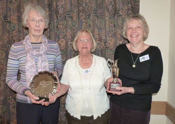Outgoing president June Gaughan presents Wendy Handford, left, with the Most Points for Monthly Competitions award and Judith Hewis with the Flower of the Month trophy   (Lin) EMN-160120-161818001