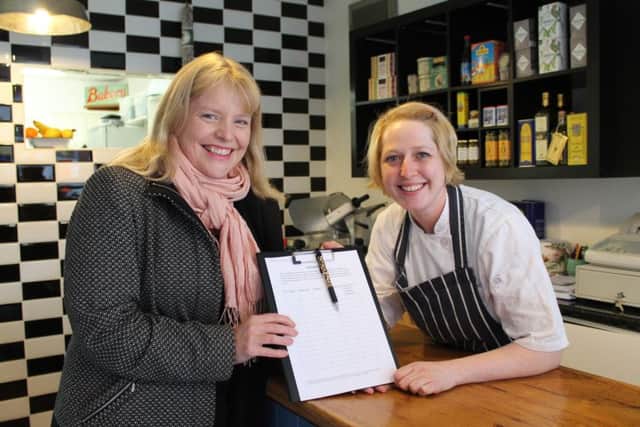 County Councillor Sarah Dodds (Lab, Louth North) hands over a petition to Roxy Warrick at Royston's Deli in Queen Street, Louth.
