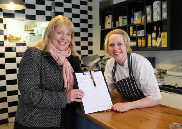 County Councillor Sarah Dodds (Lab, Louth North) hands over a petition to Roxy Warrick at Royston's Deli in Queen Street, Louth.
