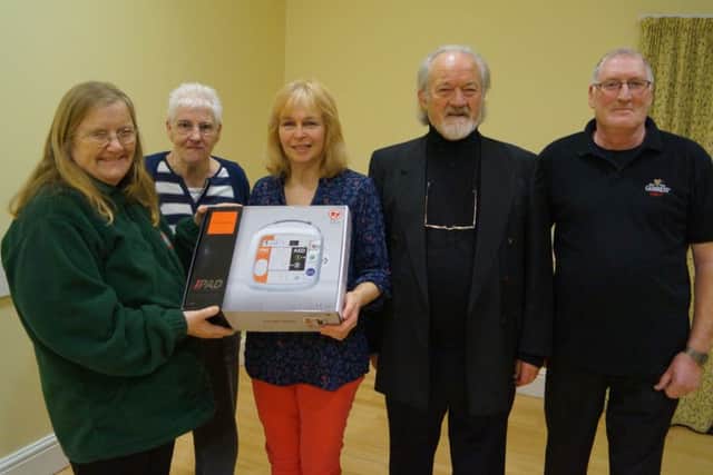 Salutation Inn owner Jo Parsons takes receipt of the defibrillator, with Rosalyn Dawson from Caistor LIVES, Coun Pat Dales, Ian Hogg and council chairman John Connolly. EMN-160802-110316001