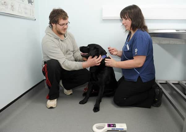 Micro chipping at Quarrington Vets. L-R Stephen Wright of Sleaford with his dog Sam 4, being micro chipped by Veternary Surgeon Jillian Kerr. EMN-160102-115604001