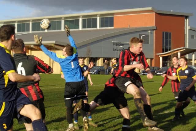 Danny Stevens jumps to catch the ball for Mablethorpe in their league derby clash with AFC Louth EMN-160102-103355002