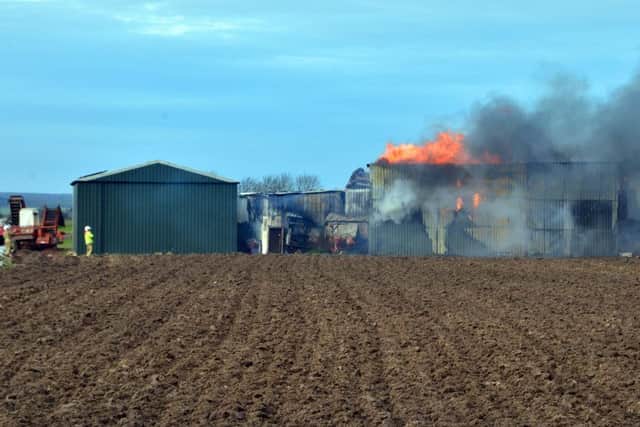 A farm building containing machinery and pallets on fire in First Drove, Gosberton Clough.