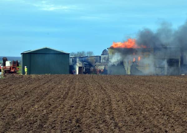 A farm building containing machinery and pallets on fire in First Drove, Gosberton Clough.
