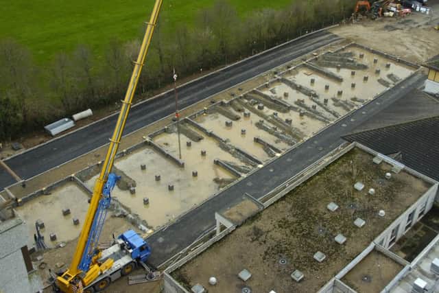 Construction staff manouver the new maternity units into place.