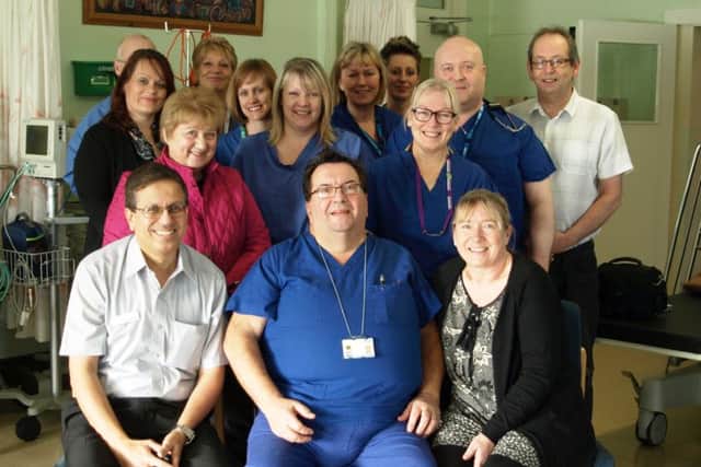 Les Parratt (centre) celebrating 50 years service with his colleagues from the theatre department.