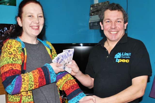 Amanda receives her £100 prize from Mark.