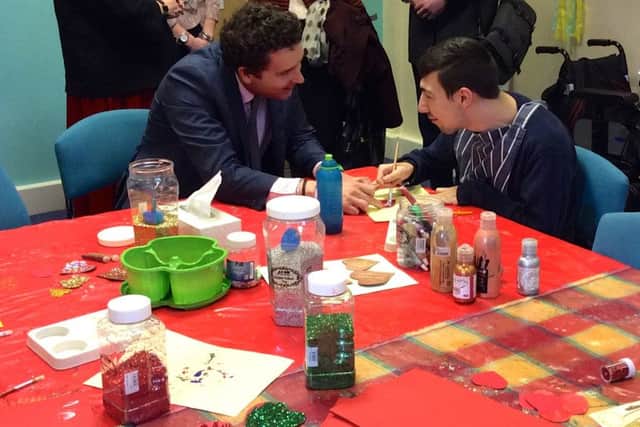 Edward Timpson helps day break regular Tom Warner with his Valentines card.