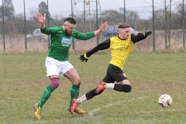 Wyberton Reserves' Liam Brackenbury goes down under a challenge from Millers' Tom Best.
