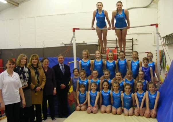 Sleaford Gymnastics Club members with their asymmetric bars and, from left - Head Coach Sammi Emsley, NKDC Community Initiatives Officer Anne-Marie Shepherd, Coun Julia Harrison of NKDC, Debbie Scott - clerk to Kirkby La Thorpe Parish Council and Coun Garry Titmus - chairman of the Liaison Panel and Mayor of Sleaford. EMN-160229-165908001