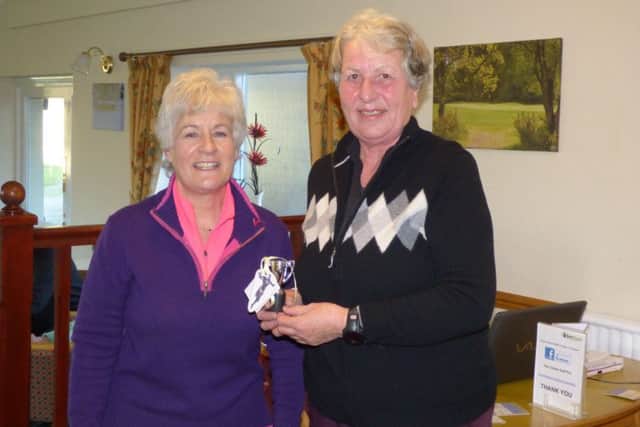 Pictured is Lady Captain Helen Grinham (left) presenting Margaret with her trophy.