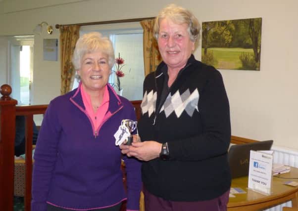 Pictured is Lady Captain Helen Grinham (left) presenting Margaret with her trophy.