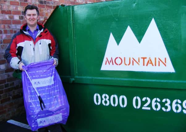 Andrew Rayner of Sleaford Town with some of the bags of litter collected by Sleaford schoolchildren on Friday and the skip loaned by Mountains skip hire. EMN-160503-091628001