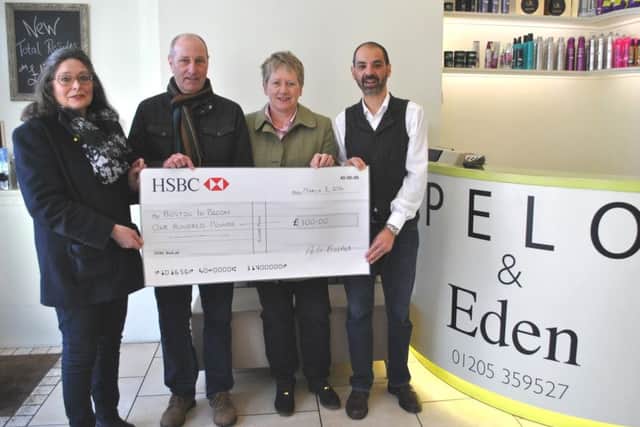 Aston Robinson, right, inside his hair and beauty salon in Wormgate, presents £100 to, from left, Alison Fairman, Paul Collingwood and Coun Claire Rylott.