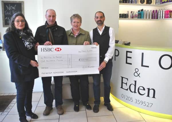 Aston Robinson, right, inside his hair and beauty salon in Wormgate, presents Â£100 to, from left,  Alison Fairman, Paul Collingwood and Coun Claire Rylott.