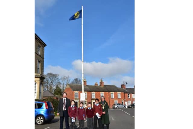 Hoisting the Commonwealth Flag for Commonwealth Day. From left - Coun Gill Odgen, NKDC Corporate Director Phil Roberts and William Alvey pupils Amelia Botto, Erin Clifford and Elliott Jackson from Year 5, and Jake Barnshaw of Year 6. EMN-160315-091918001