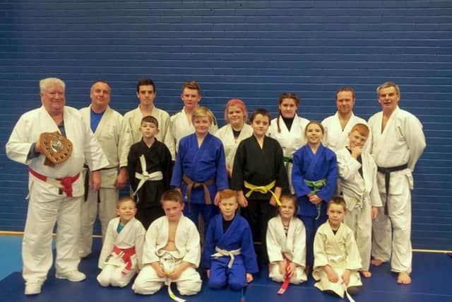 Pictured are the successful students, plus Sensei Malcolm Sawyer with the Ron Jeffery Memorial Shield. KmwWMUBGMHd8OpaFEKcl