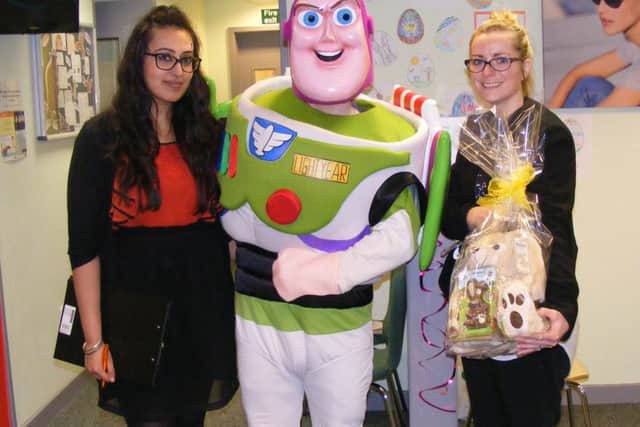 Buzz Lightyear joines Specsavers' Reena Chahal and Kathleen Gray for their Easter children's event in Sleaford. EMN-160504-094543001