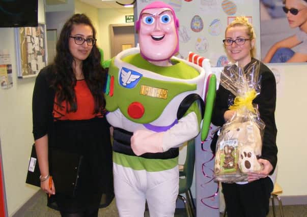 Buzz Lightyear joines Specsavers' Reena Chahal and Kathleen Gray for their Easter children's event in Sleaford. EMN-160504-094543001
