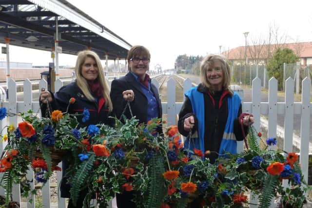 East Midlands Trains station staff Julie Gray and Rachel Coulbeck join volunteer station adopter Carolyn Sharp to put the new hanging baskets up at Skegness Train Station. ANL-160504-131715001