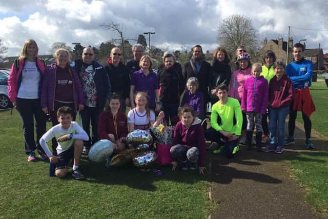Charlotte Bailey (in centre at front) completes her tenth 10k run to raise money for Sleaford Laffletics Club, greeted by members of the club and members of Sleaford Striders running club. EMN-161104-183809001