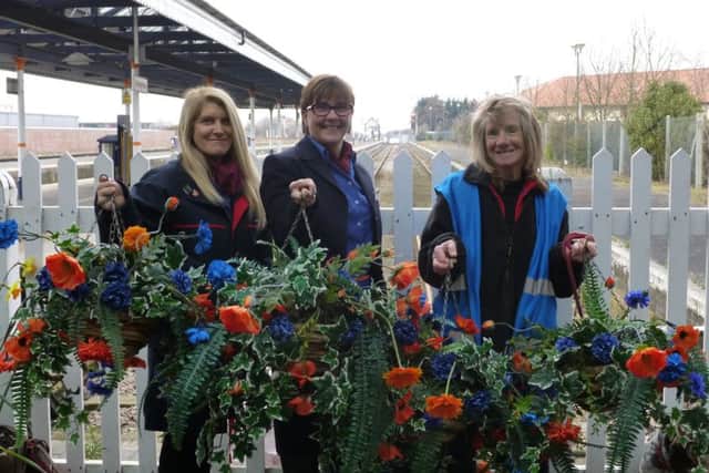 East Midlands Trains station staff Julie Gray and Rachel Coulbeck join volunteer station adopter Carolyn Sharp to put the new hanging baskets up at Skegness Train Station. ANL-160504-131715001
