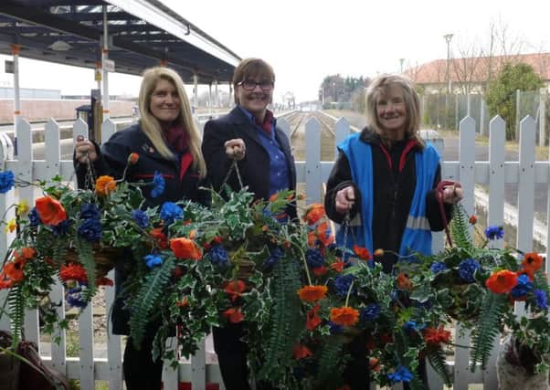 East Midlands Trains station staff Julie Gray and Rachel Coulbeck join volunteer station adopter Carolyn Sharp to put the new hanging baskets up at Skegness Train Station. ANL-160504-131715001