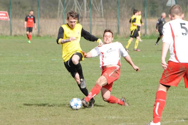 Wyberton Reserves' Reece Beauchamp gets some close attention from Skegness Town Reserves' Ben Etches.