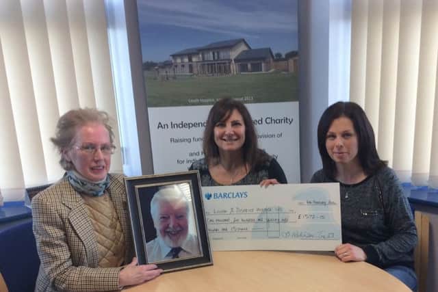 John's partner Barbara Robinson-Tester and daughter Laura Allen present their donation to Louth and District Hospice Charity Administrator, Bev Petchell.