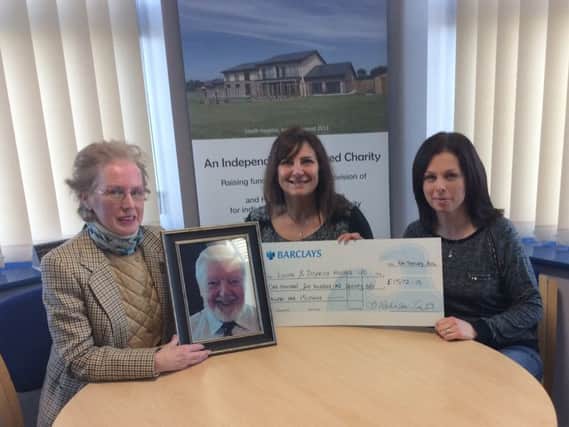 John's partner Barbara Robinson-Tester and daughter Laura Allen present their donation to Louth and District Hospice Charity Administrator, Bev Petchell.
