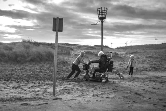 John Guillain's photo of his grandson helping a lady whose mobility scooter became stuck in sand on Skegness beach.