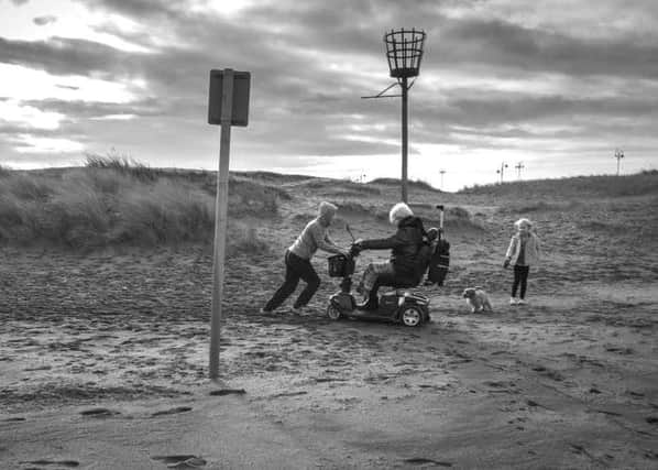 John Guillain's photo of his grandson helping a lady whose mobility scooter became stuck in sand on Skegness beach.